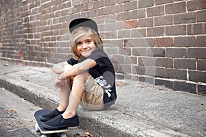 Little child sitting on a skateboard