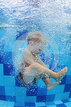 Little child swimming with fun and diving down in pool