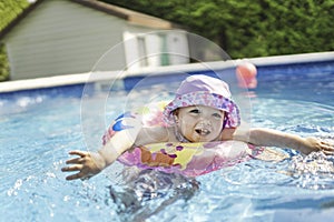 Little child swimming in the pool with buoy