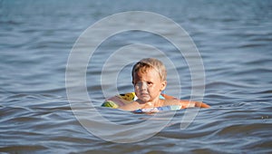 Little child swimming in the sea with life preserver