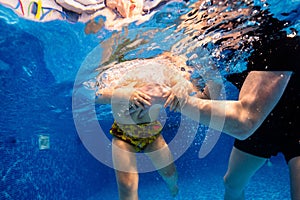 Little child swims underwater in swimming pool