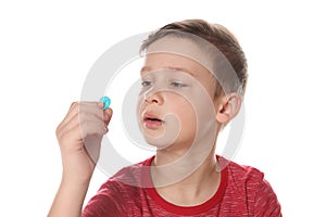 Little child taking pill on white. Danger of medicament intoxication