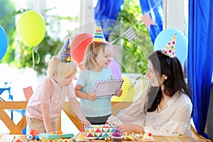 Little child and their mother celebrate birthday party with colorful decoration and cakes with colorful decoration and cake