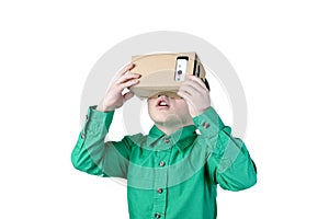 Little child uses virtual reality (VR cardboard) on white background