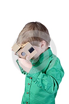 Little child uses virtual reality (VR cardboard) on white background