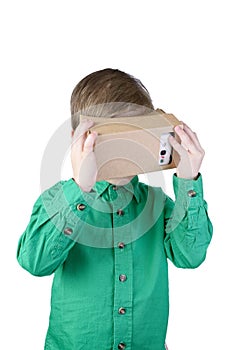 Little child uses virtual reality (VR cardboard) on white background