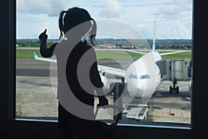 Little child waiting for boarding to flight in airport terminal