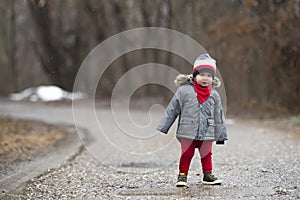 A little child is walking through the forest