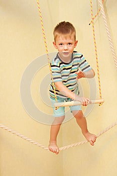 Little child walking on a tightrope in the sports complex.