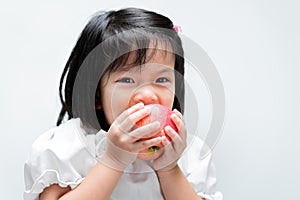 Little child was eating a red apple with gusto. Isolated white background