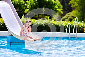 Little child on water slide in swimming pool