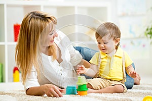 Little child and woman playing with toys