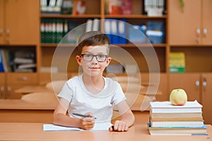 Little child writing with colorful pencils, indoors. Elementary school and education. Kid learning writing letters and numbers