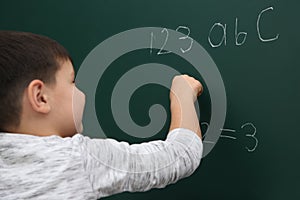 Little child writing math sum