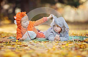 Little children in animal costumes playing in autumn forest