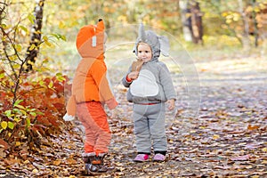Little children in animal costumes playing in autumn forest