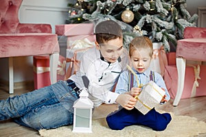 Little children with Christmas gift boxes at home. Family on Xmas eve