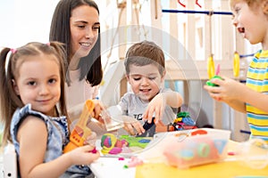 Little children engaged in playdough modeling at daycare