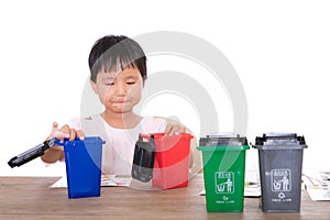 Little children in front of white background are playing sorting garbage bin model