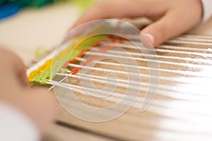 Little children hands weaving loom in art theraphy class at school. Education concept. Telar weave looom photo