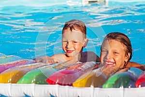 Little children playing and having fun in swimming pool with air