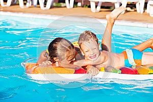 Little children playing and having fun in swimming pool with air