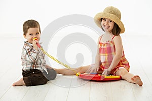 Little children playing with toy instrument