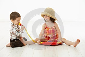 Little children playing with toy instrument