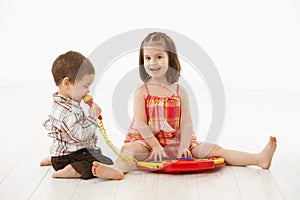 Little children playing with toy instrument