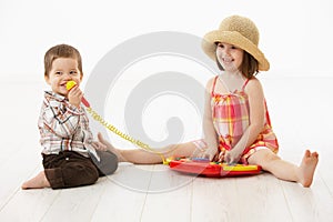 Little children playing with toy instrument