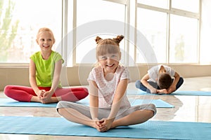 Little children practicing yoga indoors