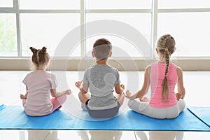 Little children practicing yoga indoors