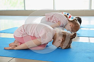 Little children practicing yoga indoors