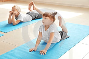 Little children practicing yoga indoors