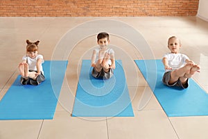 Little children practicing yoga indoors