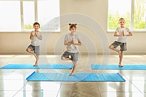 Little children practicing yoga indoors