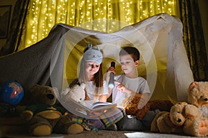 Little children reading bedtime story at home