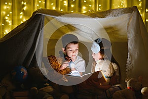 Little children reading bedtime story at home