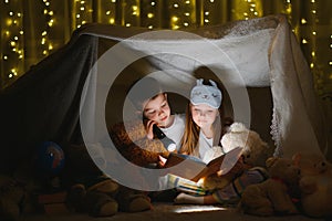 Little children reading bedtime story at home