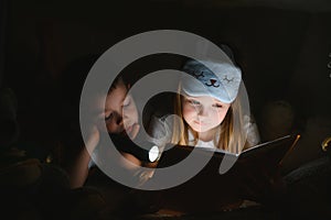 Little children reading bedtime story at home