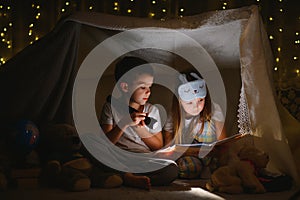 Little children reading bedtime story at home