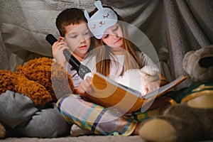 Little children reading bedtime story at home