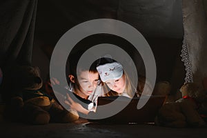 Little children reading bedtime story at home.