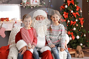 Little children sitting on authentic Santa Claus` knees