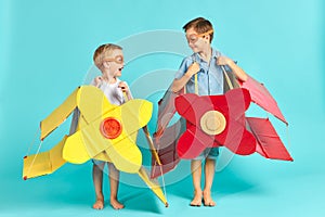 Little children in toy airplane against blue background