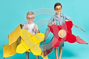 Little children in toy airplane against blue background