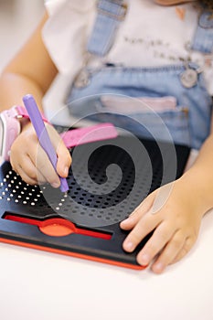 Little children using magnetic pen in kindergarden. Educational games