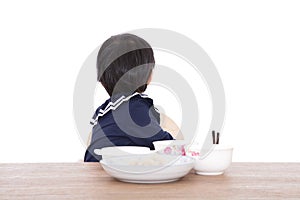 Little Chinese girl refusing to eat at the table in front of white background