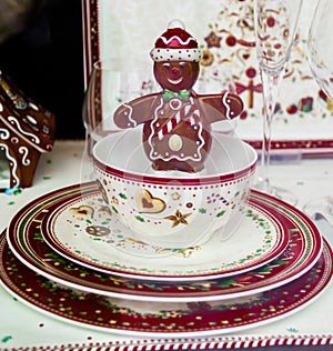 Little chocolate man smiling in porcelain cup on porcelain plates