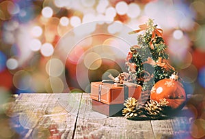 Little christmas tree on wooden table and small gift box, fir cones